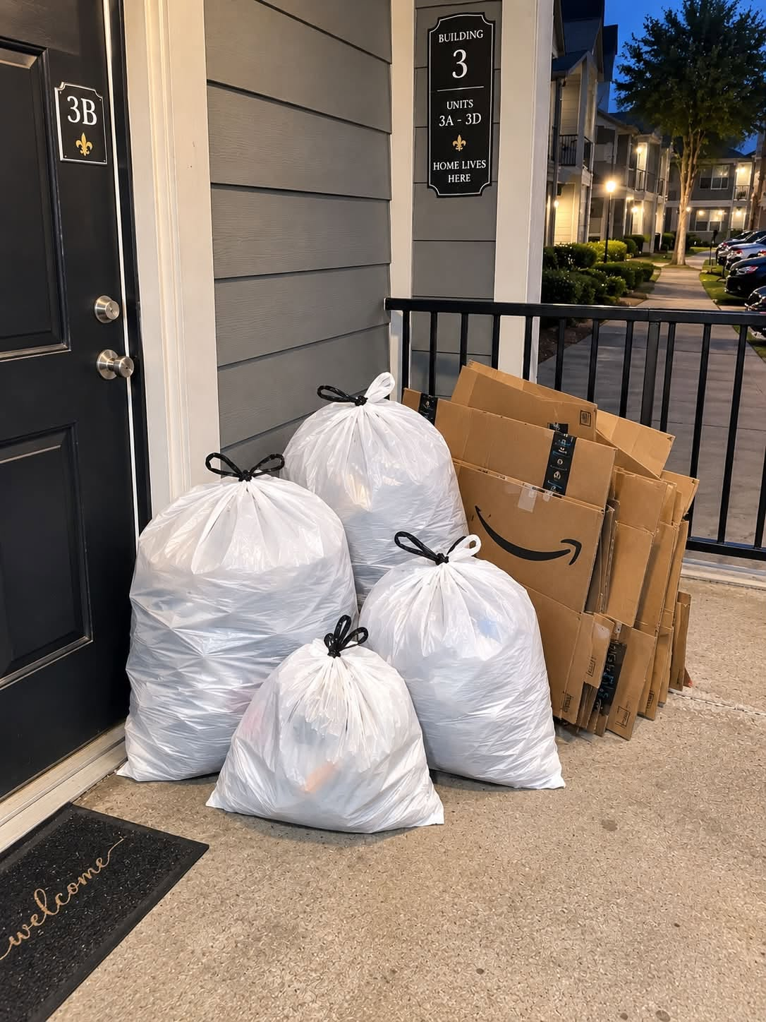 Securely tied trash bags and flattened cardboard placed outside an apartment door